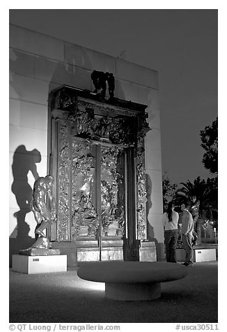 A couple contemplates Rodin's Gates of Hell at night. Stanford University, California, USA