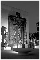 A couple contemplates Rodin's Gates of Hell at night. Stanford University, California, USA ( black and white)