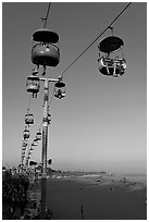 Sky glider Riders enjoy the last sunrays of the day. Santa Cruz, California, USA (black and white)