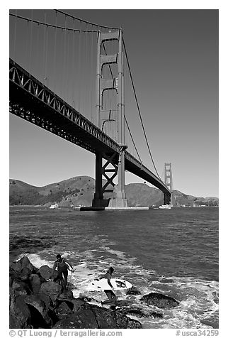 Surfers below the Golden Gate Bridge. San Francisco, California, USA