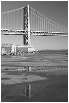 Bay Bridge reflected in water puddles. San Francisco, California, USA (black and white)