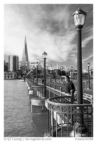 Visitor standing on pier 7, morning. San Francisco, California, USA (black and white)