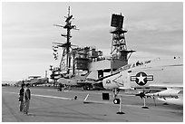 Couple looking at fighter aircraft on the Flight deck of USS Midway. San Diego, California, USA ( black and white)