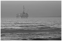 Off-shore petrol extraction  platforms, sunset. Huntington Beach, Orange County, California, USA (black and white)