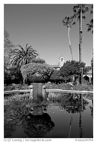 Palm trees reflected in central  courtyard basin. San Juan Capistrano, Orange County, California, USA