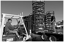 Men loading crab traps onto a truck. Morro Bay, USA (black and white)