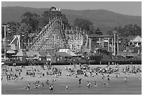 Beachgoers, and Santa Cruz boardwalk roller-coaster. Santa Cruz, California, USA ( black and white)