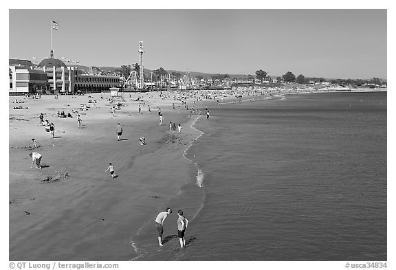 Beach with couple standing in water. Santa Cruz, California, USA (black and white)