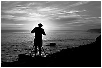Photographer on cliffs at sunset. Santa Cruz, California, USA (black and white)