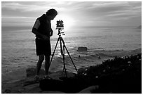 Photographer and large format camera on tripod at sunset. Santa Cruz, California, USA ( black and white)
