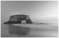 Sea arch and reflection, Natural Bridges State Park, dusk. Santa Cruz, California, USA ( black and white)