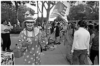 Woman in clown costume waiving American Flag, Independence Day. San Jose, California, USA (black and white)