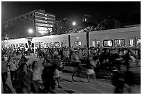 Crowds and light rail on San Carlos Avenue at night, Independence Day. San Jose, California, USA (black and white)