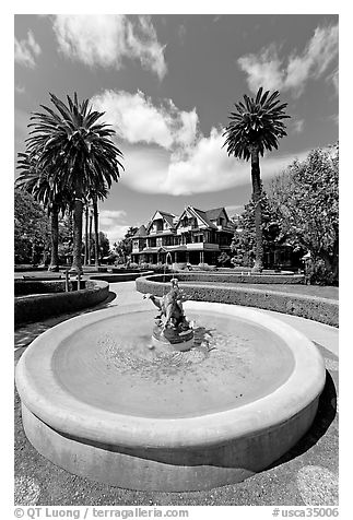 Wide view of fountain and mansion. Winchester Mystery House, San Jose, California, USA (black and white)