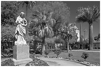 Statue, palm trees, and mission, Santa Clara University. Santa Clara,  California, USA (black and white)