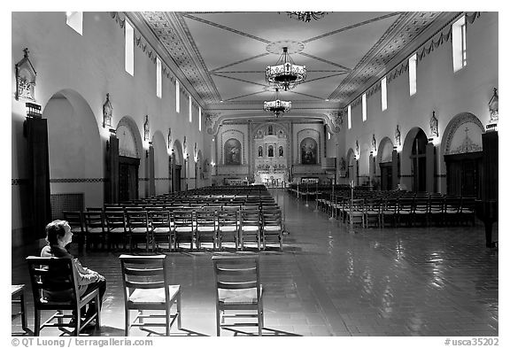 Woman sitting in chapel, Mission Santa Clara de Asis. Santa Clara,  California, USA (black and white)