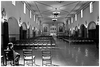 Woman sitting in chapel, Mission Santa Clara de Asis. Santa Clara,  California, USA ( black and white)