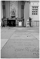 Handprints and footprints of actors and actresses in cement, Grauman theater forecourt. Hollywood, Los Angeles, California, USA (black and white)