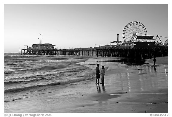 Couple on beach, with pier in the background, sunset. Santa Monica, Los Angeles, California, USA