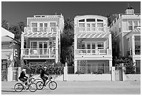 Family cycling in front of colorful beach houses. Santa Monica, Los Angeles, California, USA ( black and white)