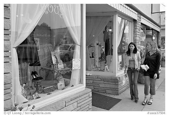 Women walking by storefront on Main Street. Half Moon Bay, California, USA (black and white)