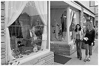 Women walking by storefront on Main Street. Half Moon Bay, California, USA ( black and white)