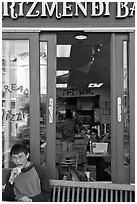 Man biting pizza outside pizzaria, Haight-Ashbury district. San Francisco, California, USA ( black and white)