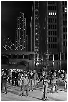 People skating on ice ring at night, Embarcadero Center. San Francisco, California, USA ( black and white)