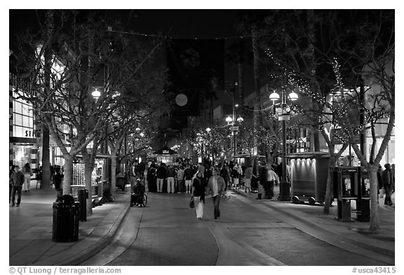 Couple walking on pedestrian Third Street by night. Santa Monica, Los Angeles, California, USA (black and white)