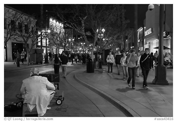 People walking past mime on Third Street Promenade. Santa Monica, Los Angeles, California, USA (black and white)