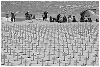 Wooden crosses, stars of David, and beachgoers. Santa Monica, Los Angeles, California, USA (black and white)