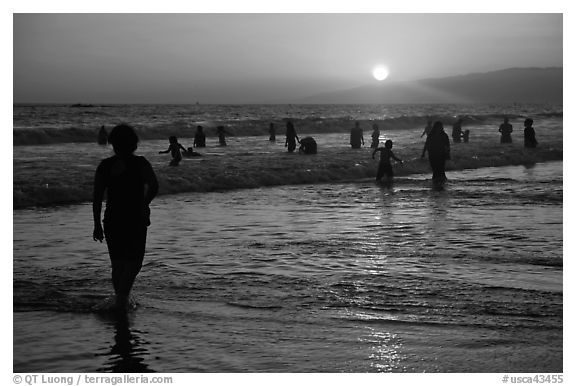 Ocean bathers at sunset, Santa Monica Beach. Santa Monica, Los Angeles, California, USA