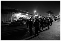 People lining up to enter a gallery at night, Bergamot Station. Santa Monica, Los Angeles, California, USA (black and white)