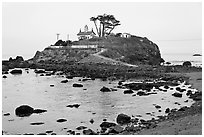 Rocky mound and lighthouse, Crescent City. California, USA (black and white)