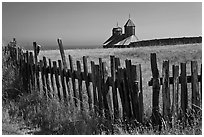 Fences, summer grass and chapel towers, Fort Ross. Sonoma Coast, California, USA (black and white)