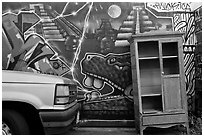 Car, mural, and discarded furniture, Mission District. San Francisco, California, USA ( black and white)