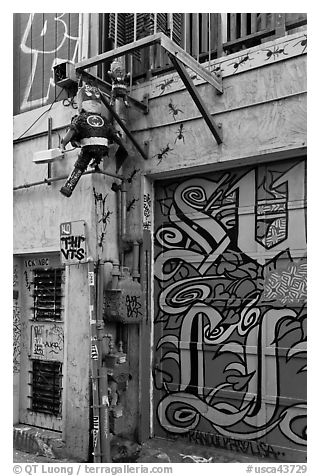 Painted garage door and suspended pinata figures, Mission District. San Francisco, California, USA (black and white)