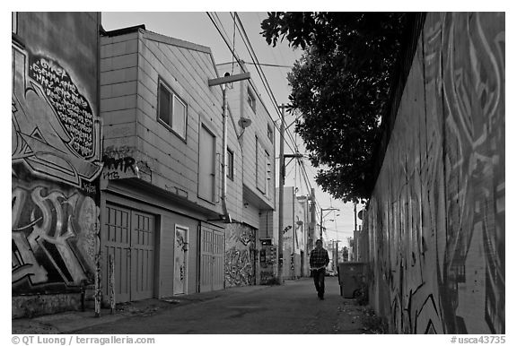 Man walking in alley, Mission District. San Francisco, California, USA (black and white)