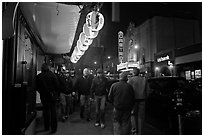 Men walking on sidewalk, Castro street at night. San Francisco, California, USA ( black and white)