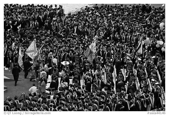 Academic flags exit amongst crow of graduates after commencement ceremony. Stanford University, California, USA (black and white)