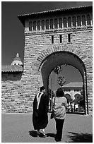 Graduate and family member walking through Main Quad. Stanford University, California, USA (black and white)