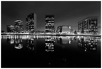 High-rise buildings and Oakland Cathedral reflected in Lake Meritt at night. Oakland, California, USA ( black and white)