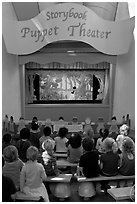 Children look at Snow white puppet show, Fairyland. Oakland, California, USA ( black and white)