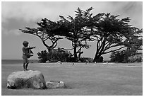 Sculpture, lawn, and cypress, Lovers Point Park. Pacific Grove, California, USA (black and white)