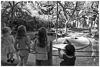 Children watching animal exhibit, Happy Hollow Zoo. San Jose, California, USA ( black and white)