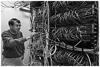 Technician rearranging data cables. Menlo Park,  California, USA ( black and white)