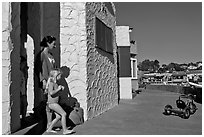 Family steps out of colorful cottage. Capitola, California, USA ( black and white)