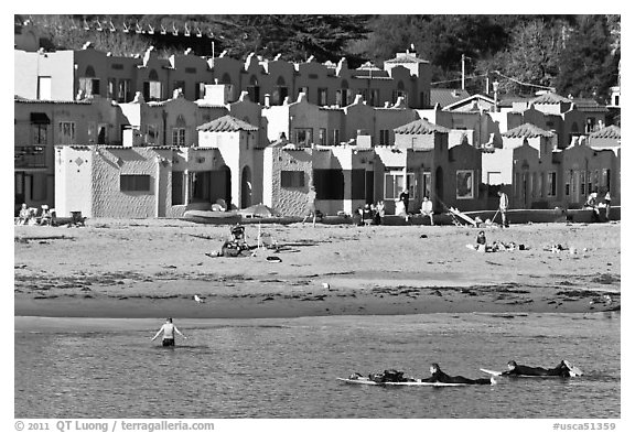 Surfers, beach, and Venetian hotel cottages. Capitola, California, USA (black and white)
