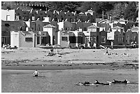 Surfers, beach, and Venetian hotel cottages. Capitola, California, USA ( black and white)