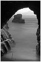 Ocean seen from sea arch at sunset, Davenport. California, USA (black and white)